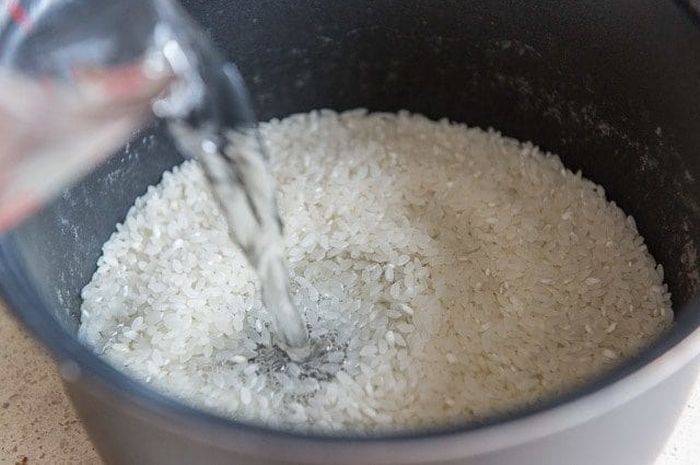 ریختن اب در برنج آبکش